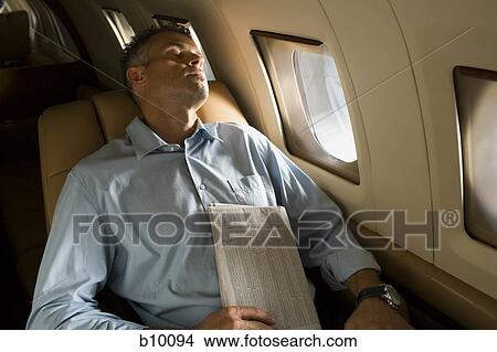 High angle view of a businessman sleeping in an airplane View Large Photo Image Picture - High angle view of a businessman sleeping in an airplane. Fotosearch