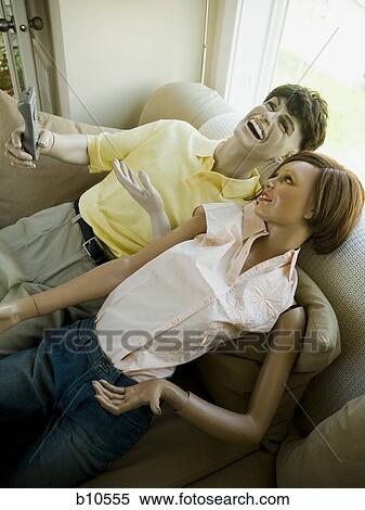 Stock Photography - High angle view of a male mannequin and a female mannequin reclining on a couch. Fotosearch