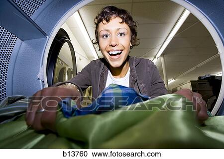 Inside dryer at Laundromat with woman removing clothing View Large Photo Image Stock Image - Inside dryer at Laundromat with woman removing clothing. Fotosearch