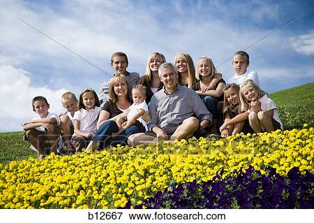 Stock Photo - Large family group on hill with happy face floral display. Fotosearch