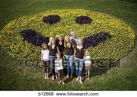 Stock Photo - Large family group on hill with happy face floral display. Fotosearch
