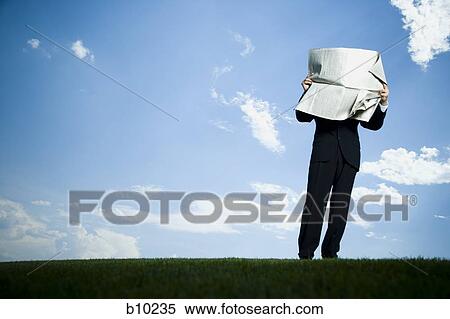 Low angle view of a businessman reading a newspaper View Large Photo Image Stock Photography - Low angle view of a businessman reading a newspaper. Fotosearch