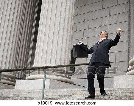 Low angle view of a male lawyer laughing and walking down the steps of a courthouse View Large Photo Image Stock Photo - Low angle view of a male lawyer laughing and walking down the steps of a courthouse. Fotosearch