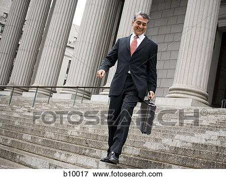 Low angle view of a male lawyer walking down the steps of a courthouse View Large Photo Image Stock Photo - Low angle view of a male lawyer walking down the steps of a courthouse. Fotosearch