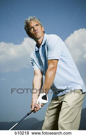 Low angle view of a man playing golf View Large Photo Image Stock Photo - Low angle view of a man playing golf. Fotosearch