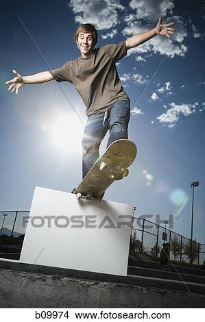 Picture - Low angle view of a teenage boy skateboarding. Fotosearch