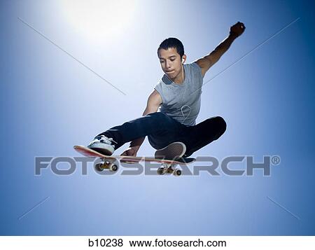 Low angle view of a teenage boy skateboarding View Large Photo Image Stock Photo - Low angle view of a teenage boy skateboarding. Fotosearch