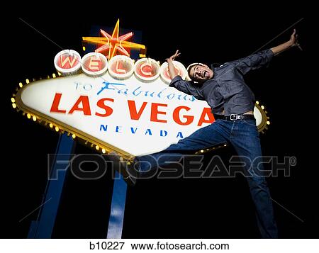 Low angle view of a young man jumping in front of a welcome sign, Las Vegas, Nevada, USA View Large Photo Image Stock Photo - Low angle view of a young man jumping in front of a welcome sign, Las Vegas, Nevada, USA. Fotosearch