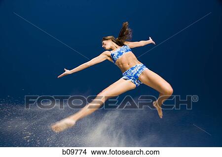 Low angle view of a young woman jumping View Large Photo Image Picture - Low angle view of a young woman jumping. Fotosearch