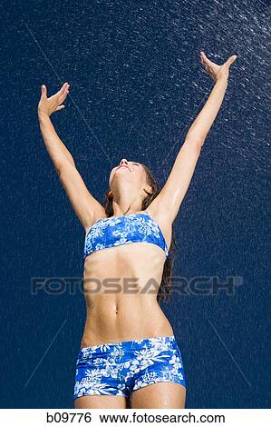 Low angle view of a young woman with her arms raised View Large Photo Image Stock Photograph - Low angle view of a young woman with her arms raised. Fotosearch
