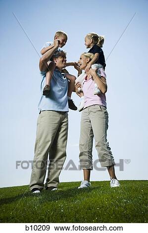 Low angle view of parents carrying their two children on their shoulders View Large Photo Image Stock Photo - Low angle view of parents carrying their two children on their shoulders. Fotosearch