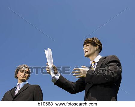Stock Photo - Low angle view of two mannequins portraying businessmen. Fotosearch