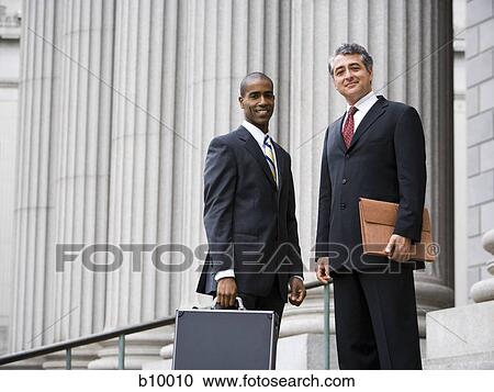 Low angle view of two men smiling and standing in front of a courthouse View Large Photo Image Stock Image - Low angle view of two men smiling and standing in front of a courthouse. Fotosearch