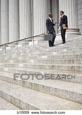 Low angle view of two men standing on the steps of a courthouse View Large Photo Image Stock Photo - Low angle view of two men standing on the steps of a courthouse. Fotosearch