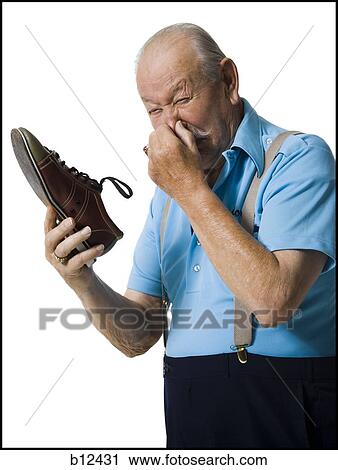 Stock Image - Male bowler sniffing stinky bowling shoes. Fotosearch