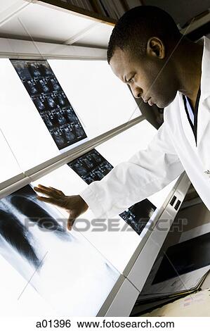 Stock Photograph - Male doctor looking at chest x-rays. Fotosearch