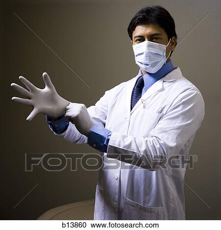 Stock Image - Male doctor or dentist with surgical mask and gloves. Fotosearch