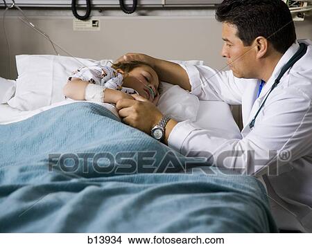Picture - Male doctor with young girl in hospital. Fotosearch