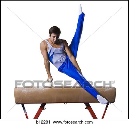 Stock Image - Male gymnast performing routines on vaulting horse. Fotosearch