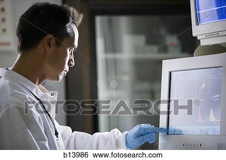 Stock Photograph - Male lab technician looking at monitors. Fotosearch