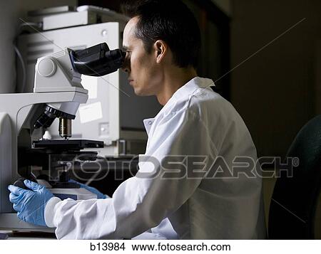 Male laboratory technician looking in microscope View Large Photo Image Picture - Male laboratory technician looking in microscope. Fotosearch