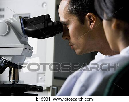 Male laboratory technician looking in microscope View Large Photo Image Stock Image - Male laboratory technician looking in microscope. Fotosearch