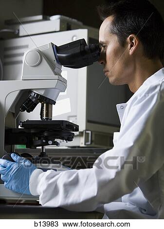 Male laboratory technician looking in microscope View Large Photo Image Stock Image - Male laboratory technician looking in microscope. Fotosearch