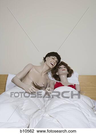 Male mannequin and a female mannequin reclining on the bed and laughing View Large Photo Image Stock Image - Male mannequin and a female mannequin reclining on the bed and laughing. Fotosearch