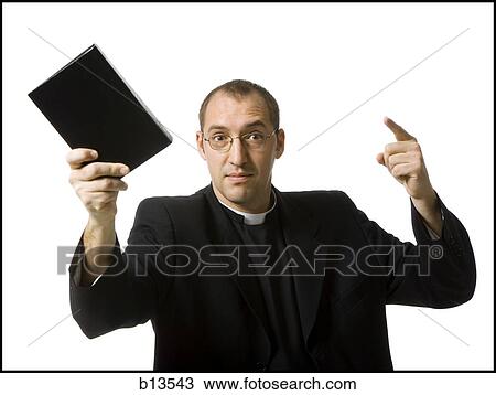 Stock Image - Male priest with bible pointing. Fotosearch