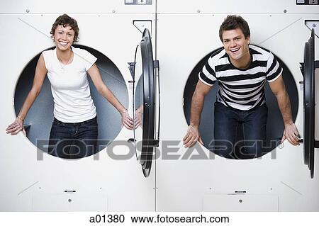 Man and woman in Laundromat dryers smiling View Large Photo Image Stock Image - Man and woman in Laundromat dryers smiling. Fotosearch