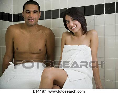 Stock Photo - Man and woman in steam bath with towels smiling. Fotosearch