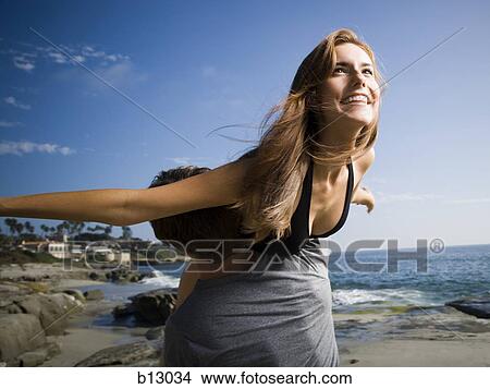Man carrying his girlfriend on beach View Large Photo Image Picture - Man carrying his girlfriend on beach. Fotosearch