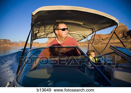 Man driving boat with young girl View Large Photo Image Stock Photo - Man driving boat with young girl. Fotosearch