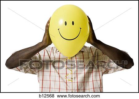 Man holding a happy face balloon View Large Photo Image Stock Photo - Man holding a happy face balloon. Fotosearch