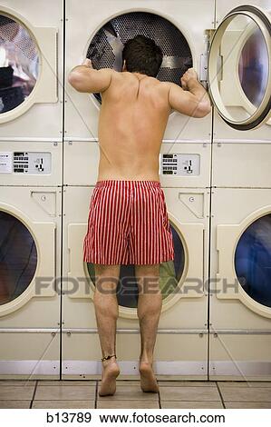 Man in boxers looking in dryer at Laundromat View Large Photo Image Stock Photo - Man in boxers looking in dryer at Laundromat. Fotosearch
