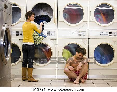 Man in boxers sleeping at Laundromat with woman removing clothing from dryer View Large Photo Image Stock Image - Man in boxers sleeping at Laundromat with woman removing clothing from dryer. Fotosearch
