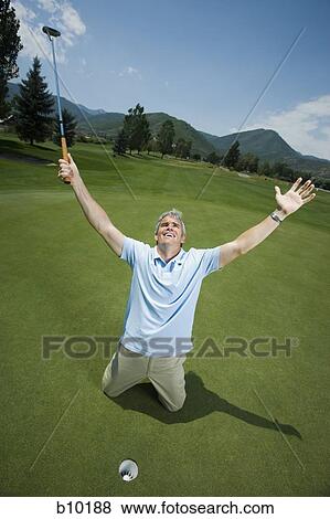 Man kneeling near a golf hole with his arms raised View Large Photo Image Stock Photo - Man kneeling near a golf hole with his arms raised. Fotosearch
