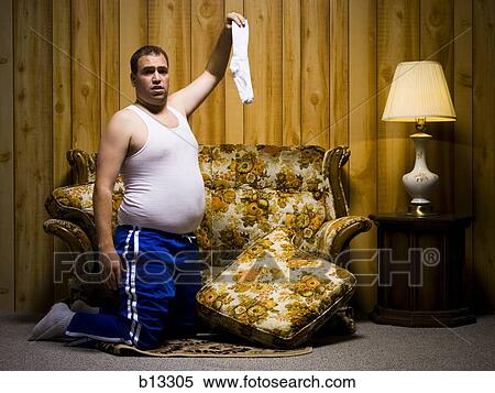 Stock Photography - Man kneeling with sock. Fotosearch