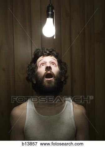 Man looking up at light bulb View Large Photo Image Stock Photo - Man looking up at light bulb. Fotosearch