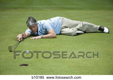 Man lying near a golf hole View Large Photo Image Stock Photography - Man lying near a golf hole. Fotosearch
