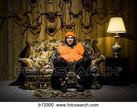 Man on sofa with antlers View Large Photo Image Stock Image - Man on sofa with antlers. Fotosearch
