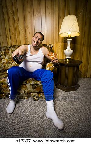 Man on sofa with pizza and TV remote smiling View Large Photo Image Stock Photo - Man on sofa with pizza and TV remote smiling. Fotosearch