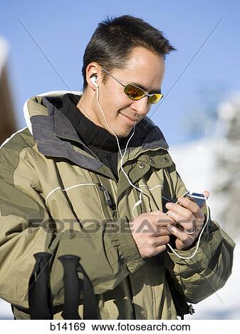 Man outdoors in winter with mp3 player smiling View Large Photo Image Stock Photo - Man outdoors in winter with mp3 player smiling. Fotosearch