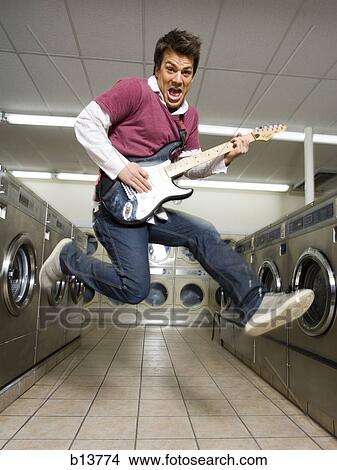 Man playing electric guitar at Laundromat View Large Photo Image Picture - Man playing electric guitar at Laundromat. Fotosearch