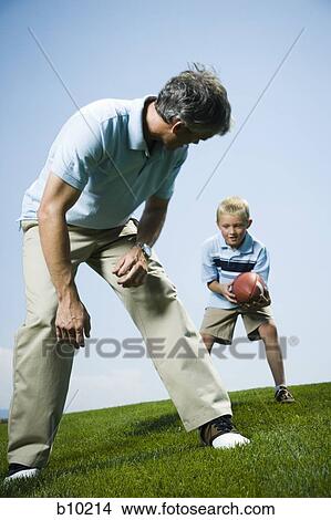 Picture - Man playing football with his son. Fotosearch