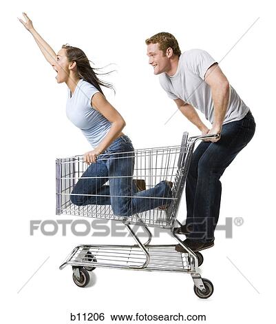 Stock Photograph - Man pushing shopping cart with girlfriend inside. Fotosearch