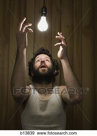 Stock Photo - Man reaching up to light bulb. Fotosearch