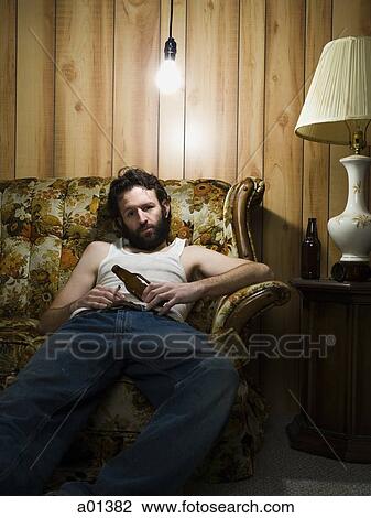 Man sitting on sofa with cigarette and beer bottle View Large Photo Image Stock Image - Man sitting on sofa with cigarette and beer bottle. Fotosearch