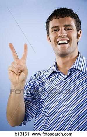 Stock Image - Man smiling peace sign. Fotosearch