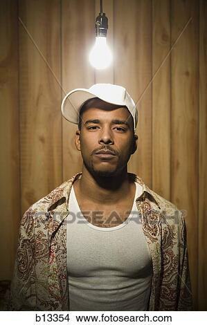 Picture - Man standing under light bulb. Fotosearch